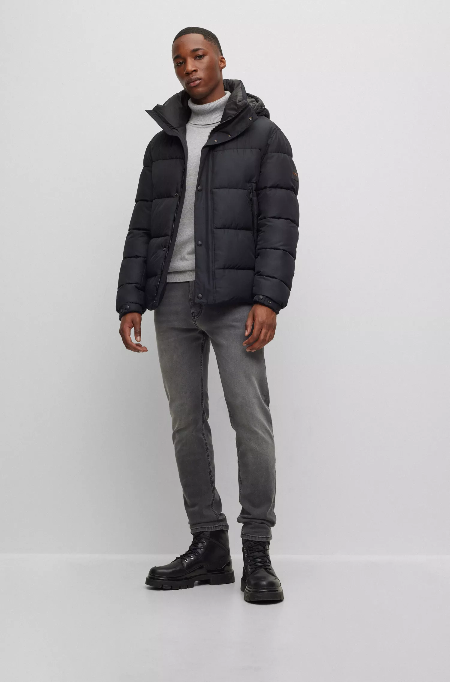 Jaqueta puffer com capuz BOSS laranja, repelente à água e com emblema da marca.