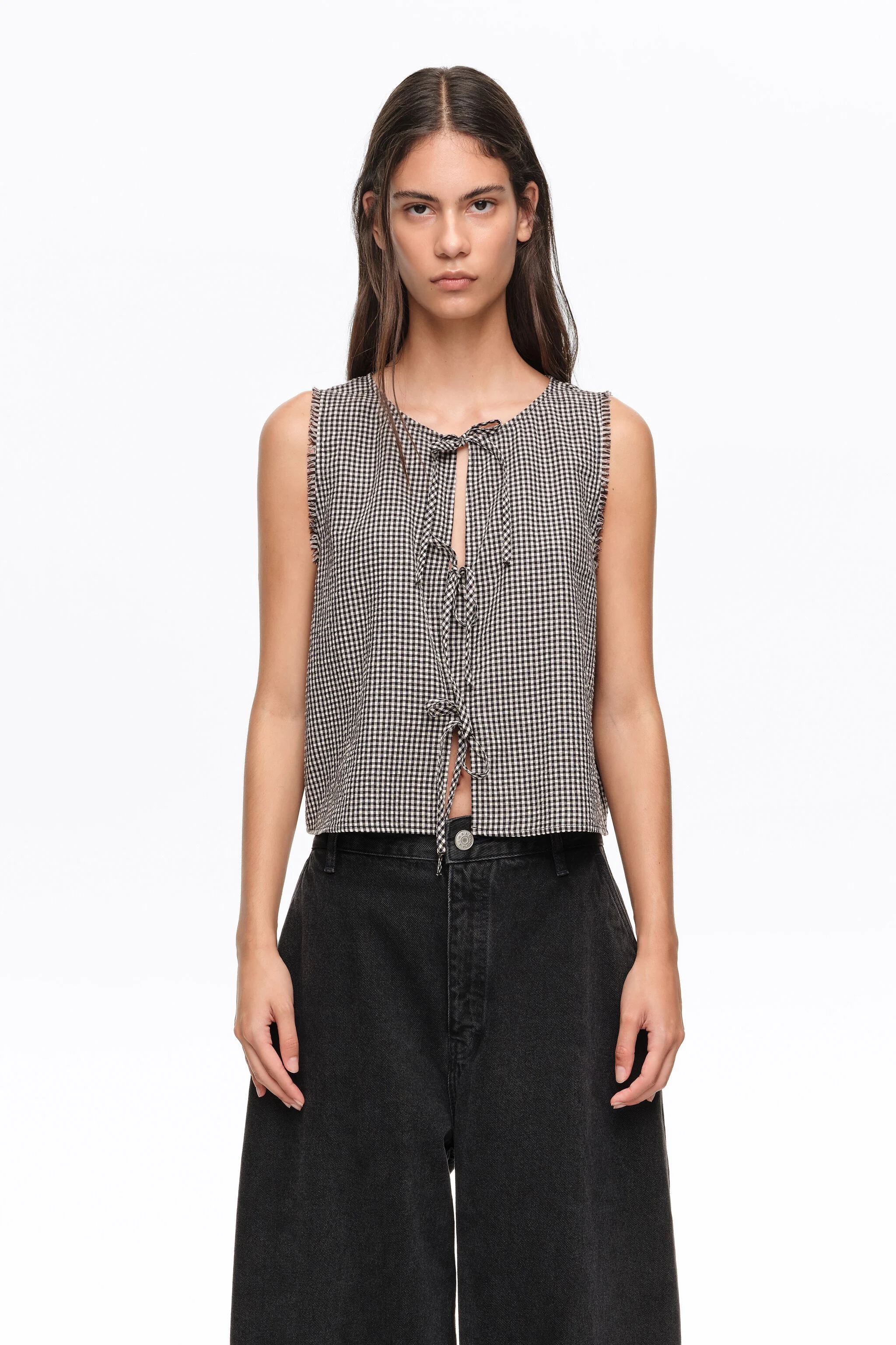 Blusa xadrez preta com laços e detalhes desfiados.