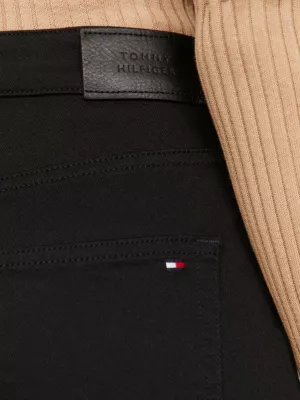 Calça jeans preta de cintura alta e corte reto, estilo cigarrete.
