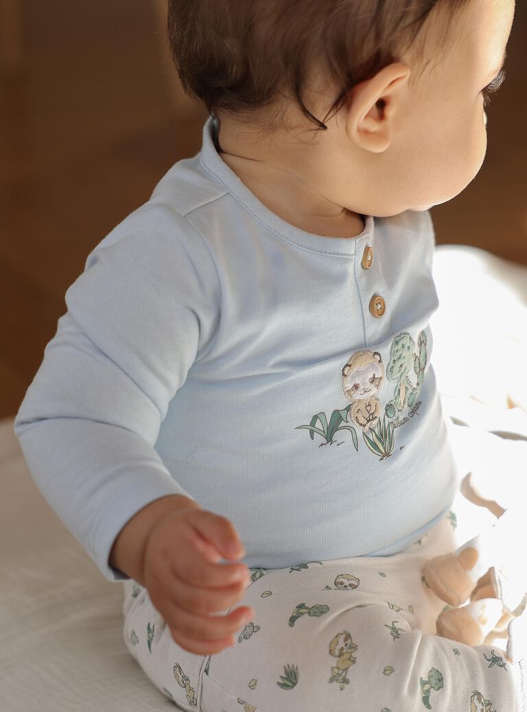 Body-T-shirt bleu, pantalon beige et chaussettes vert d'eau