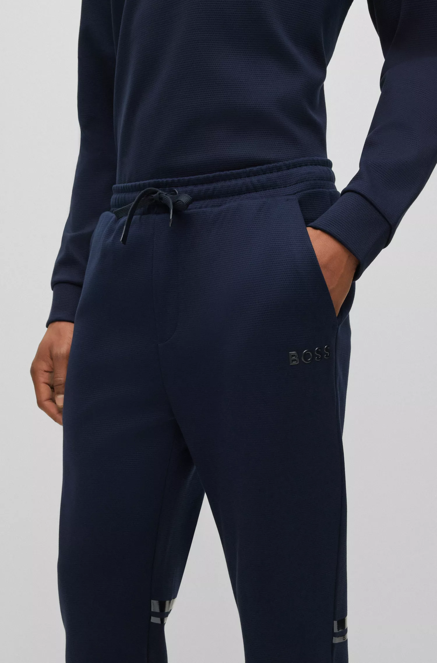 Calça de fato de treino BOSS verde, corte relaxado, com logótipo em efeito espelhado.
