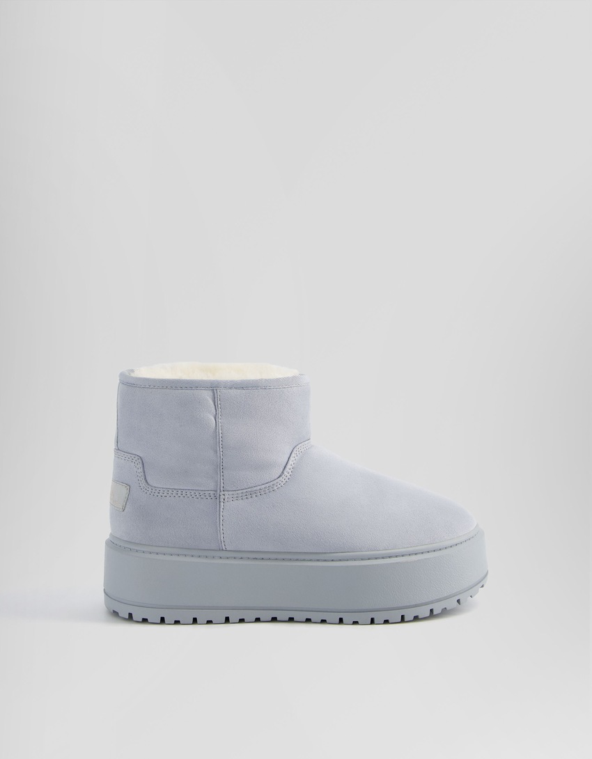 Botas de cano curto com plataforma e forro de pele sintética.