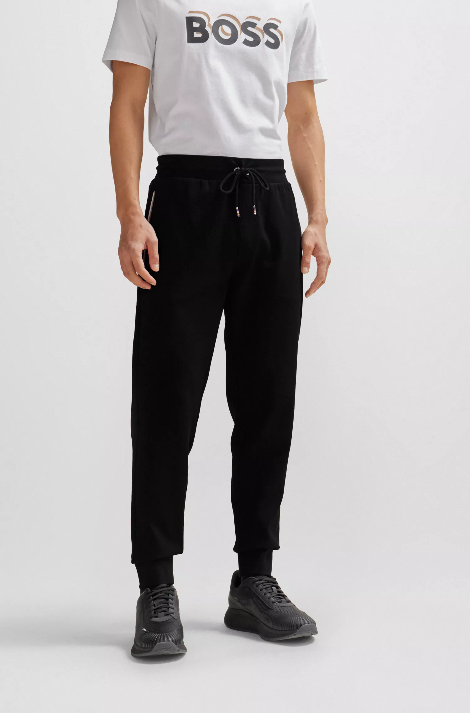 Calça de fato de treino BOSS em mistura de algodão preto com detalhes de riscas características da marca.