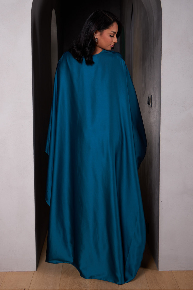 Robe ample ceinturée et satinée bleue avec empiècement cape