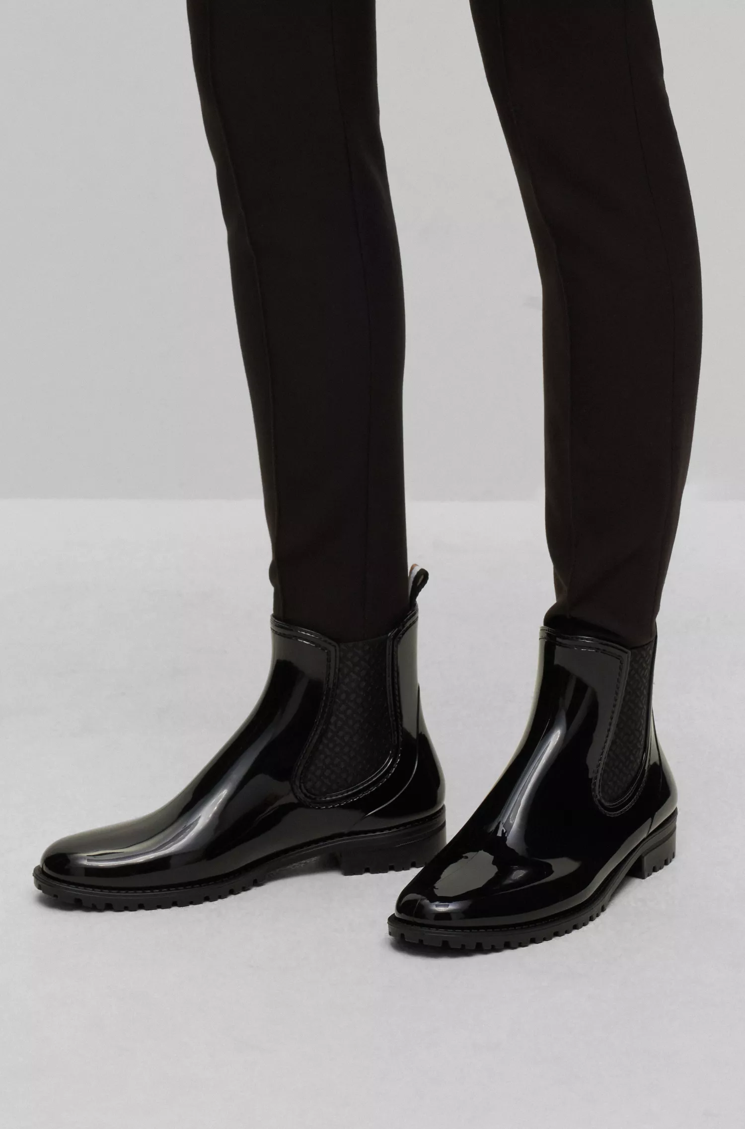Botas de chuva BOSS estilo Chelsea pretas com acabamento brilhante e detalhes da marca.