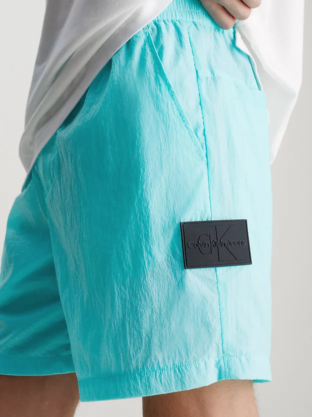 Calções de nylon com corte relaxado e detalhes em relevo.