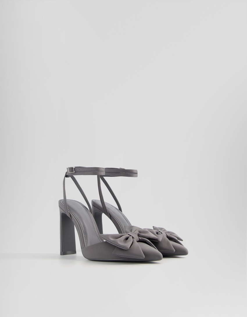 Sapatos de salto alto com tira no tornozelo e laço.