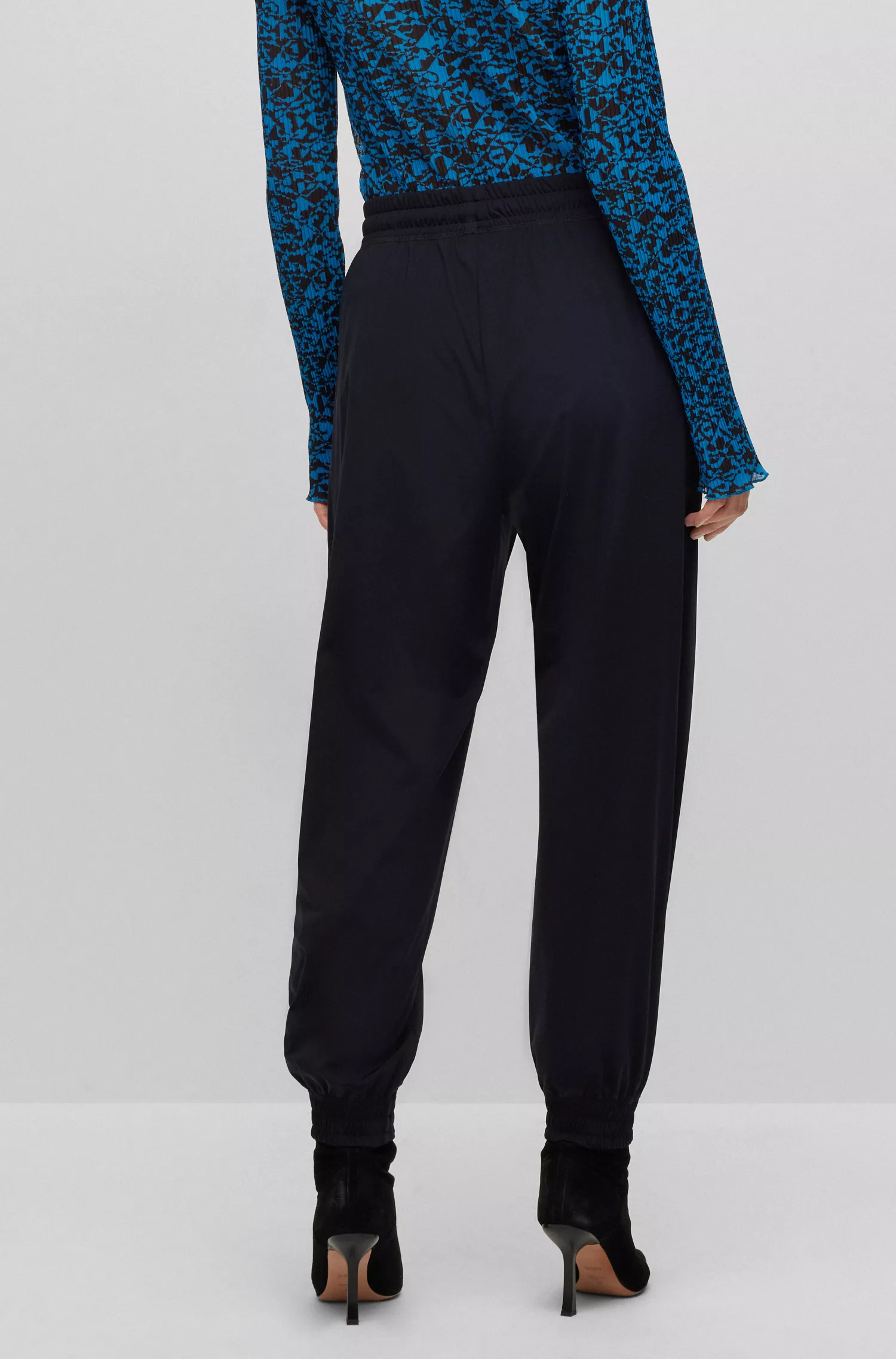 Calça BOSS preta, modelagem relaxada com cordão, em malha elástica de alta performance.