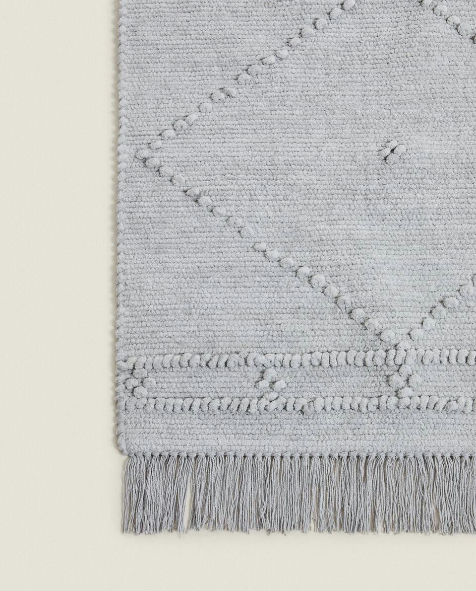 Tapete infantil de chenille com estampa de diamante e franjas.