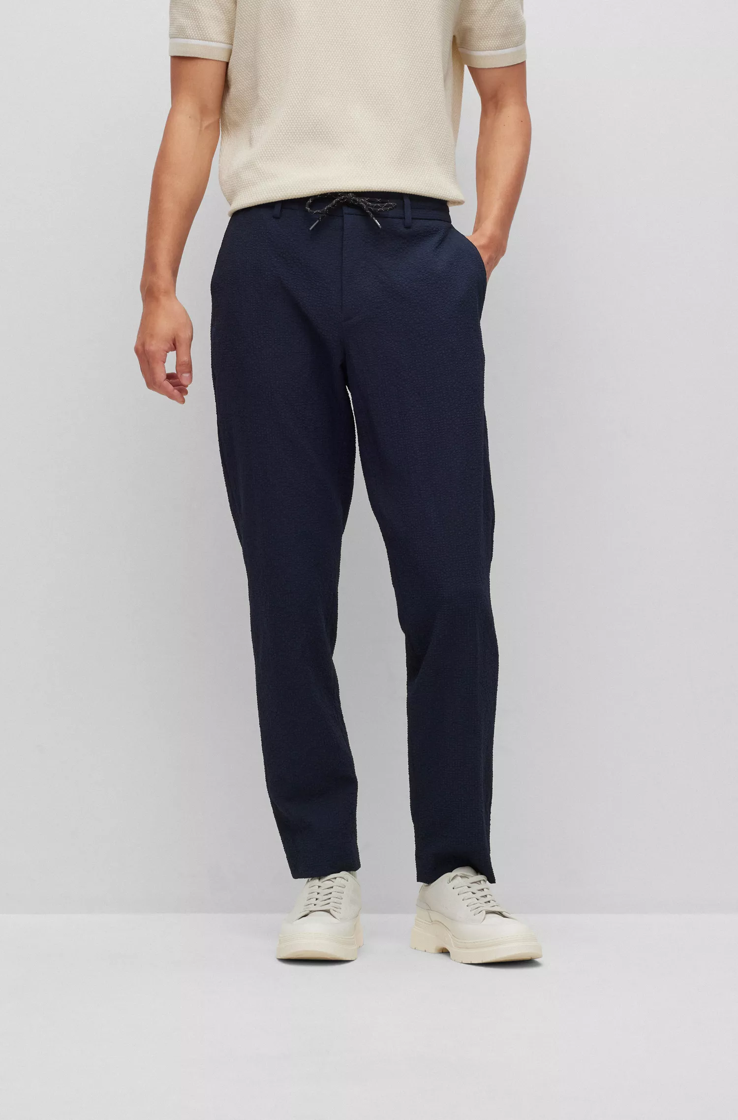 Calça BOSS preta de corte slim em tecido seersucker de alta performance com elasticidade.