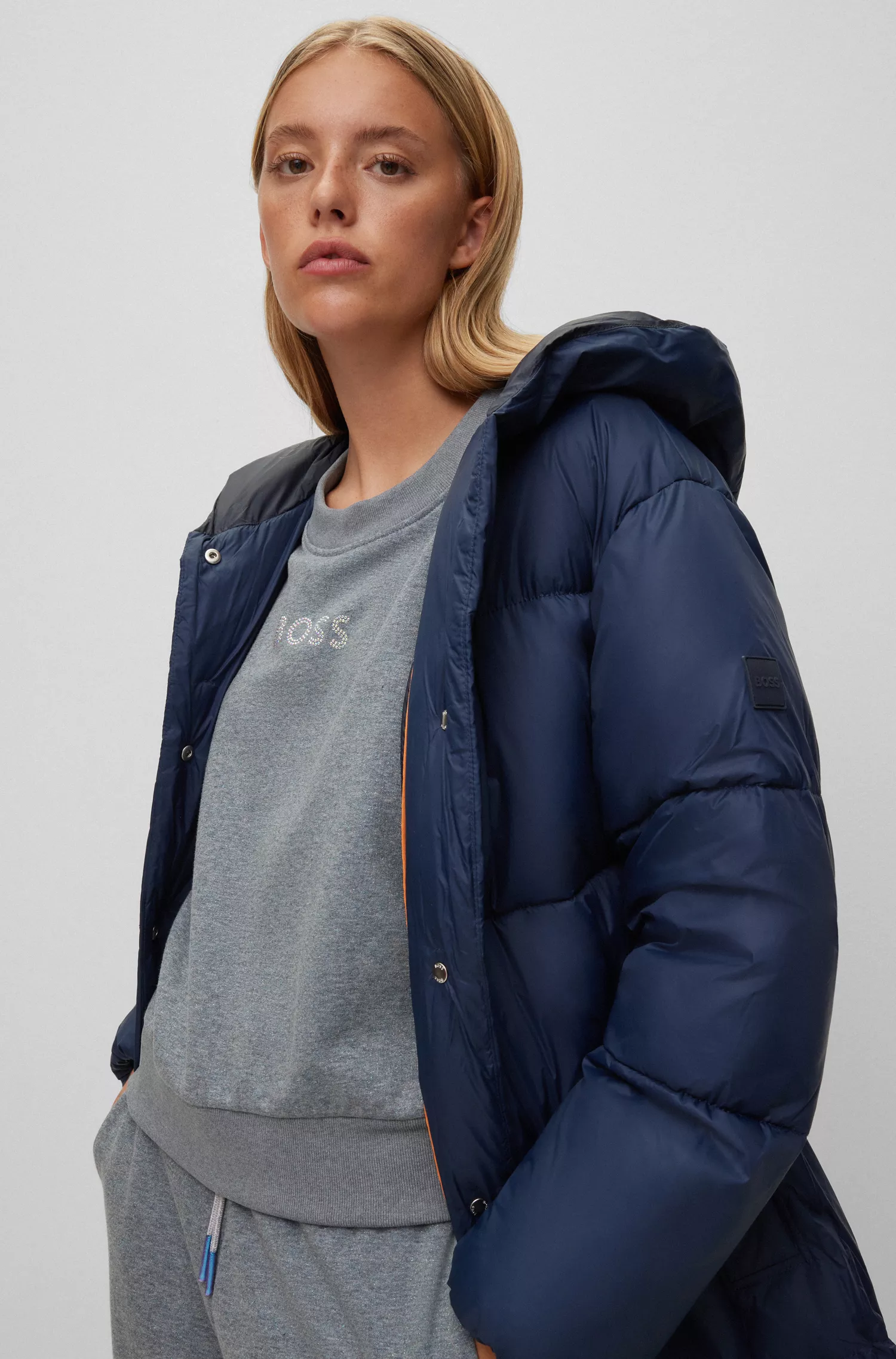 Jaqueta puffer BOSS laranja, modelagem oversized e acabamento repelente à água.