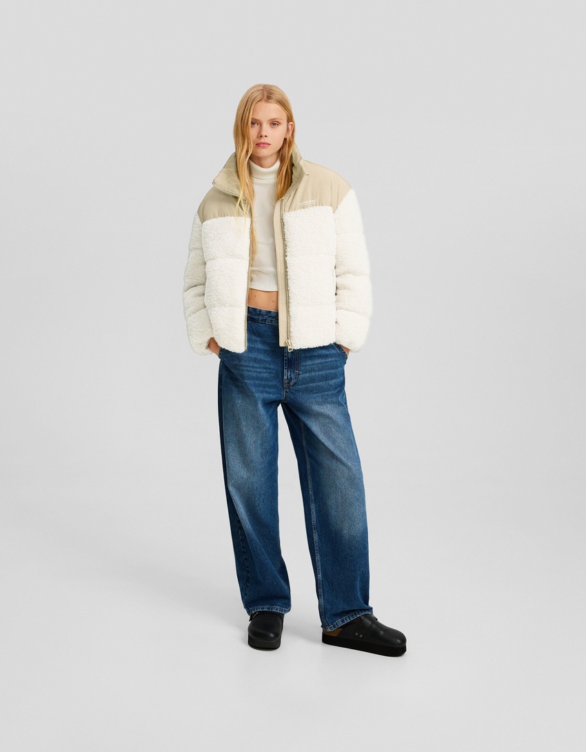 Jaqueta puffer com detalhes contrastantes em imitação de pele de carneiro e nylon.