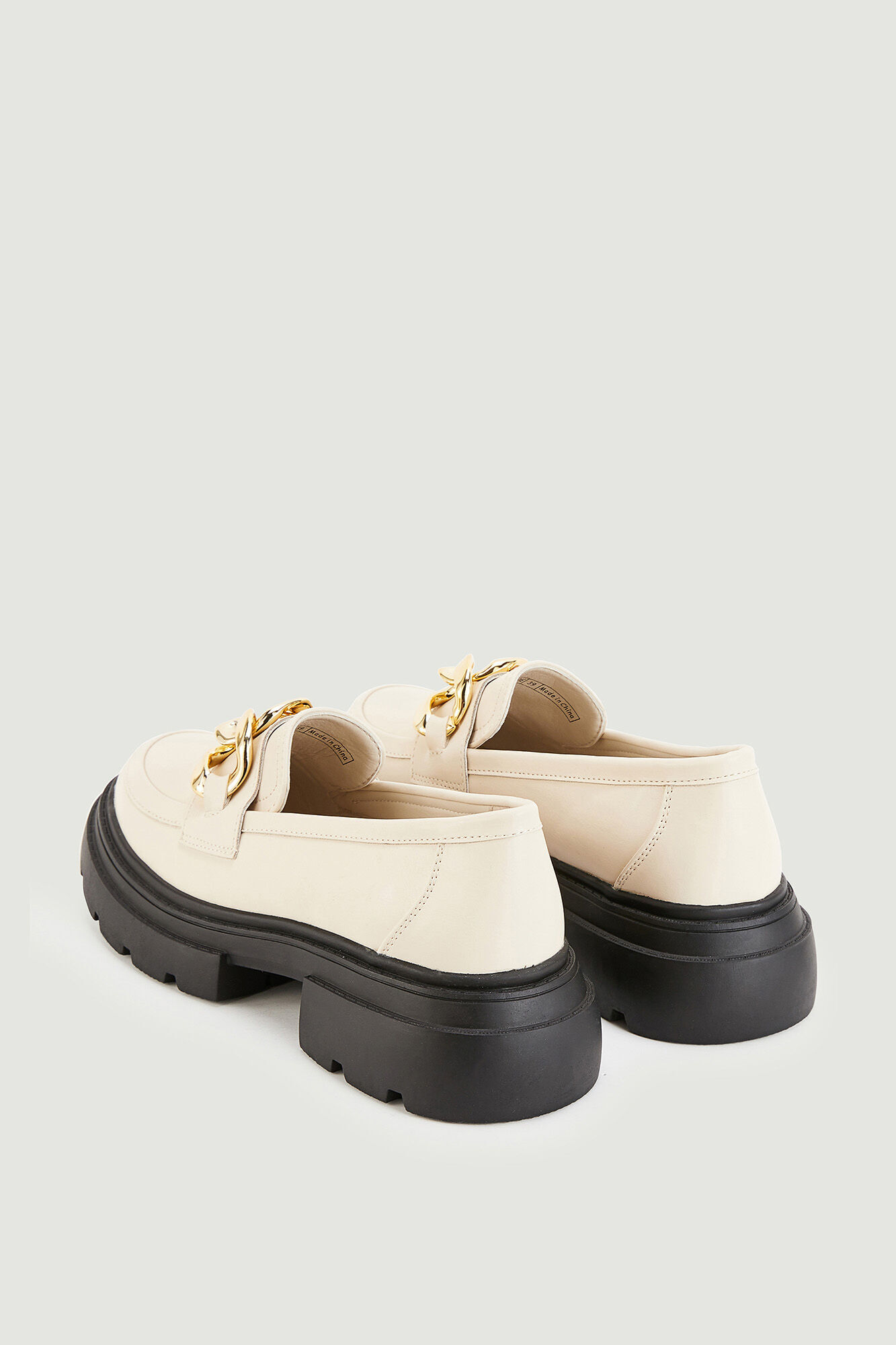 Mocassins robustos com fivelas douradas em imitação de couro.