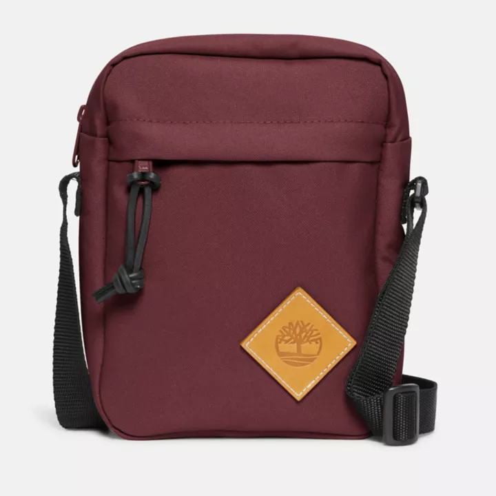 Bolsa transversal Timberland Core, unissex, na cor bordô.