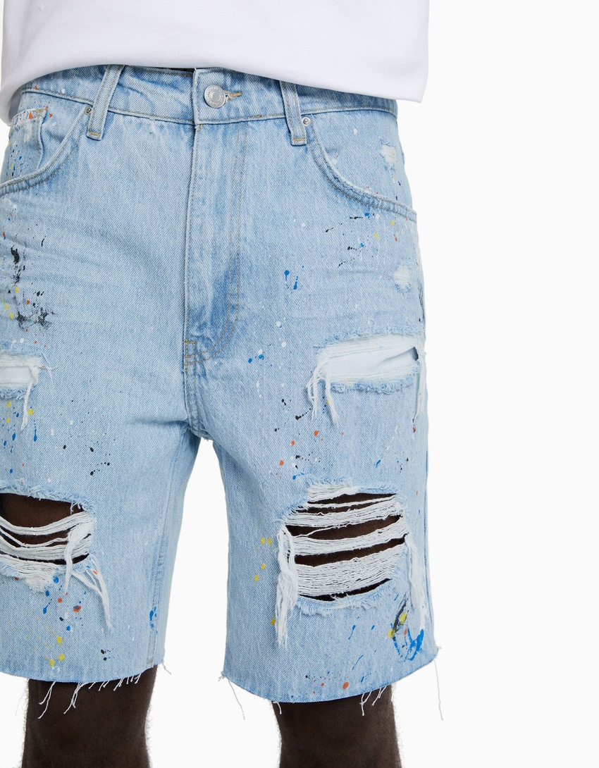 Bermuda jeans rasgada com respingos de tinta