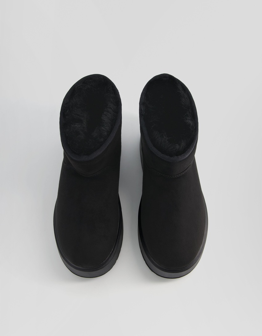 Botas de cano curto com plataforma e forro de pele sintética.
