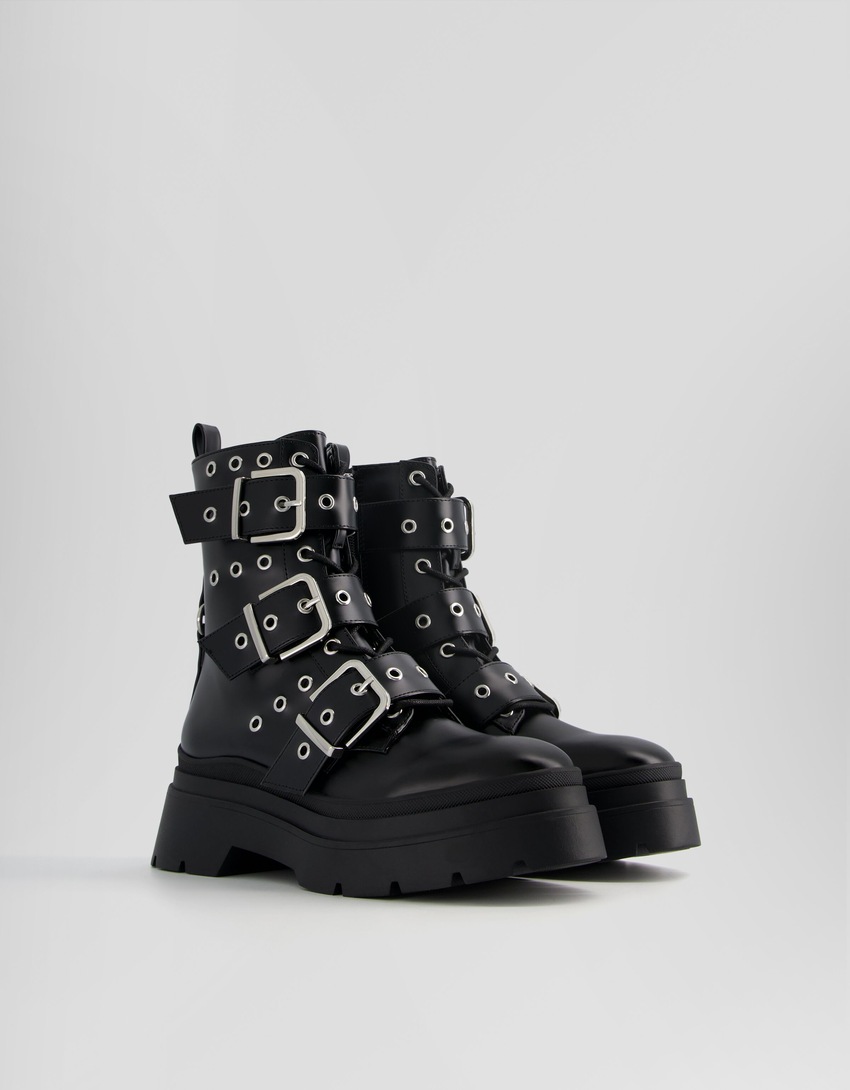 Botas de cano curto sem salto, com tiras, ilhós e fivelas.