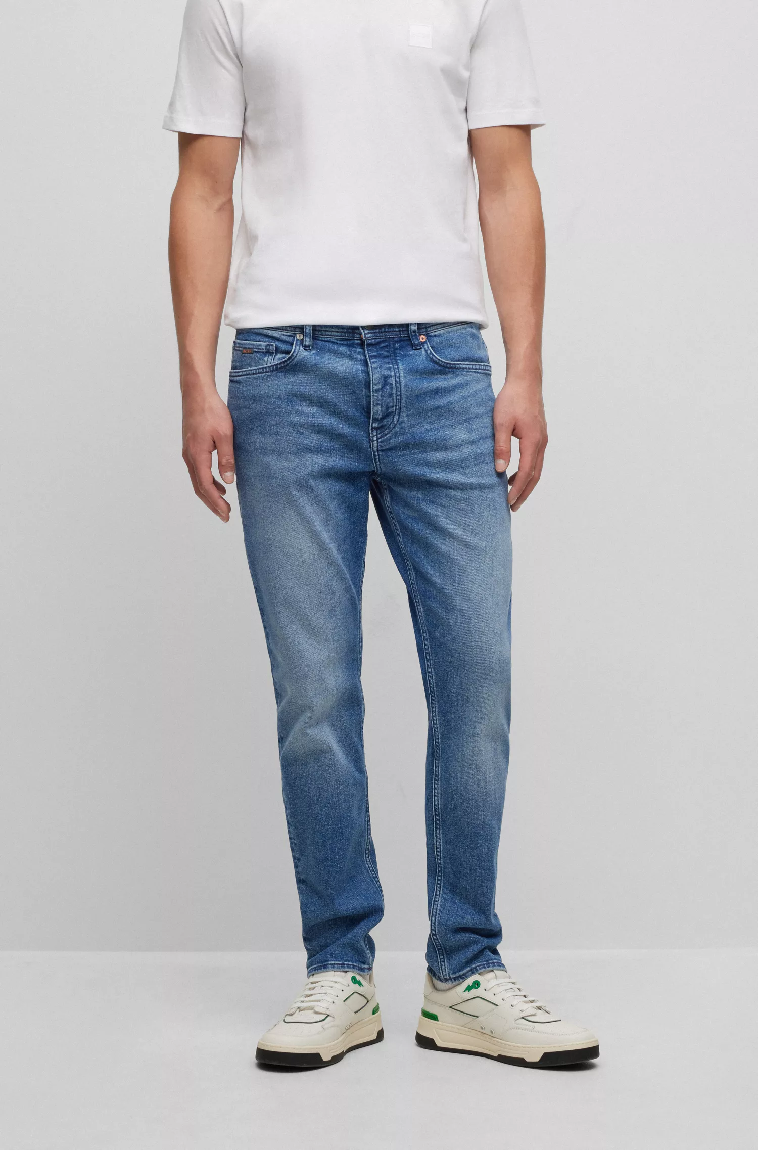 Calça jeans BOSS laranja, corte afunilado, em denim azul com elasticidade confortável.