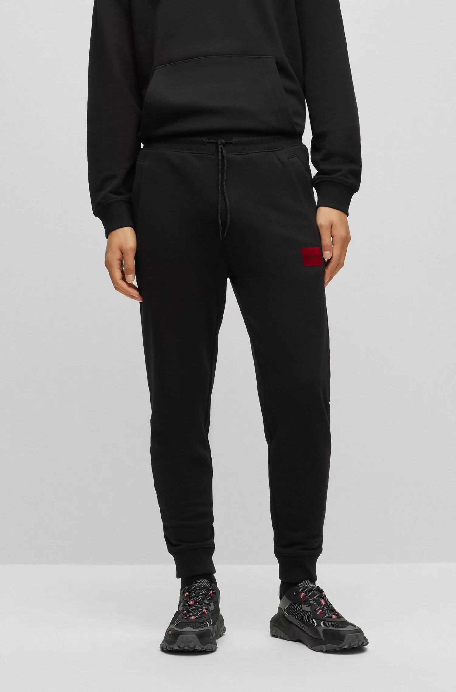 Calça de fato de treino HUGO em tecido atoalhado de algodão vermelho com logótipo de efeito metálico.