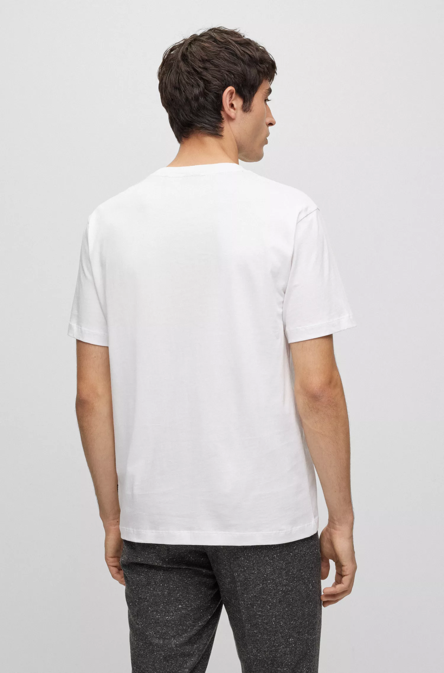 Camiseta BOSS preta em algodão interlock com pétalas de flores artificiais.