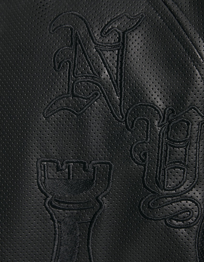 Camisa de manga curta com efeito de couro e bordado vazado.