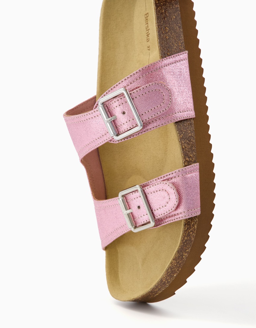 Sandálias rasteiras metálicas com fivelas.