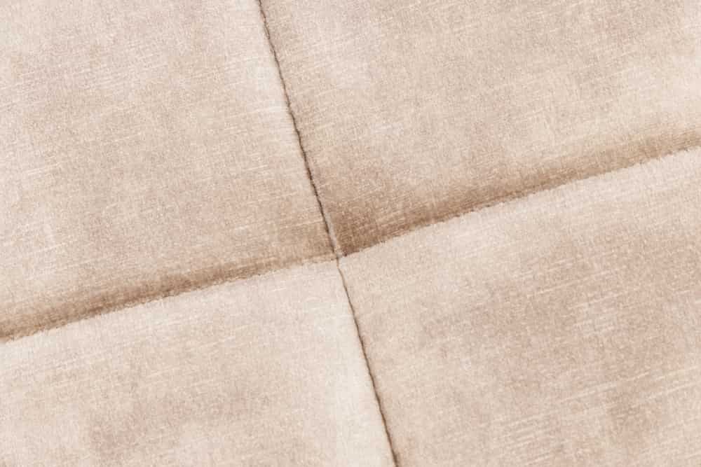 Moderner Hocker SCANDINAVIA champagner beige Samt schwarze Metallbeine Fußhocker