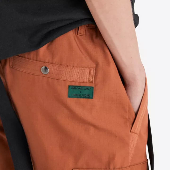 Calça de moletom Timberland x Nina Chanel Abney com suspensórios na cor marrom.