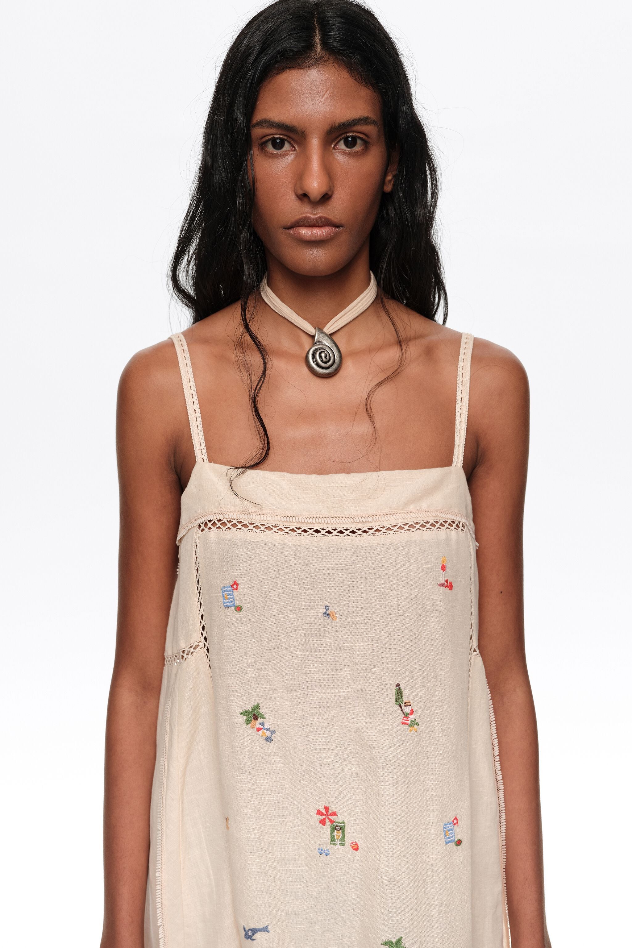 Vestido curto evasê em linho cor areia com bordado.