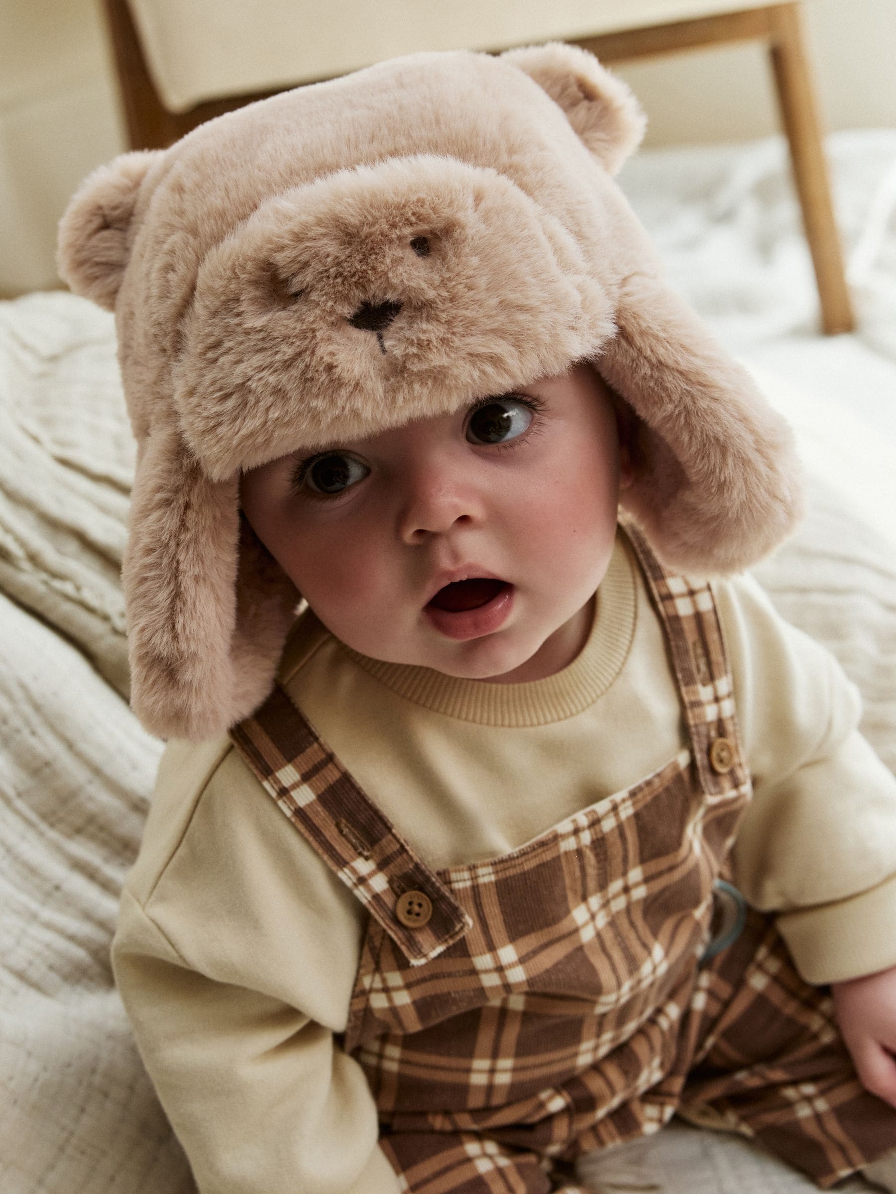 Beige imitatiebont met beergezicht. - Babymuts met oorkleppen
