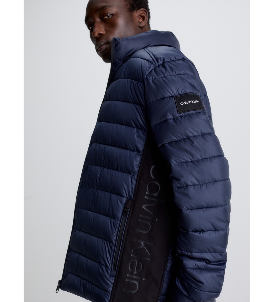 Jaqueta Calvin Klein de plumas, confeccionada com materiais reciclados, na cor azul marinho.