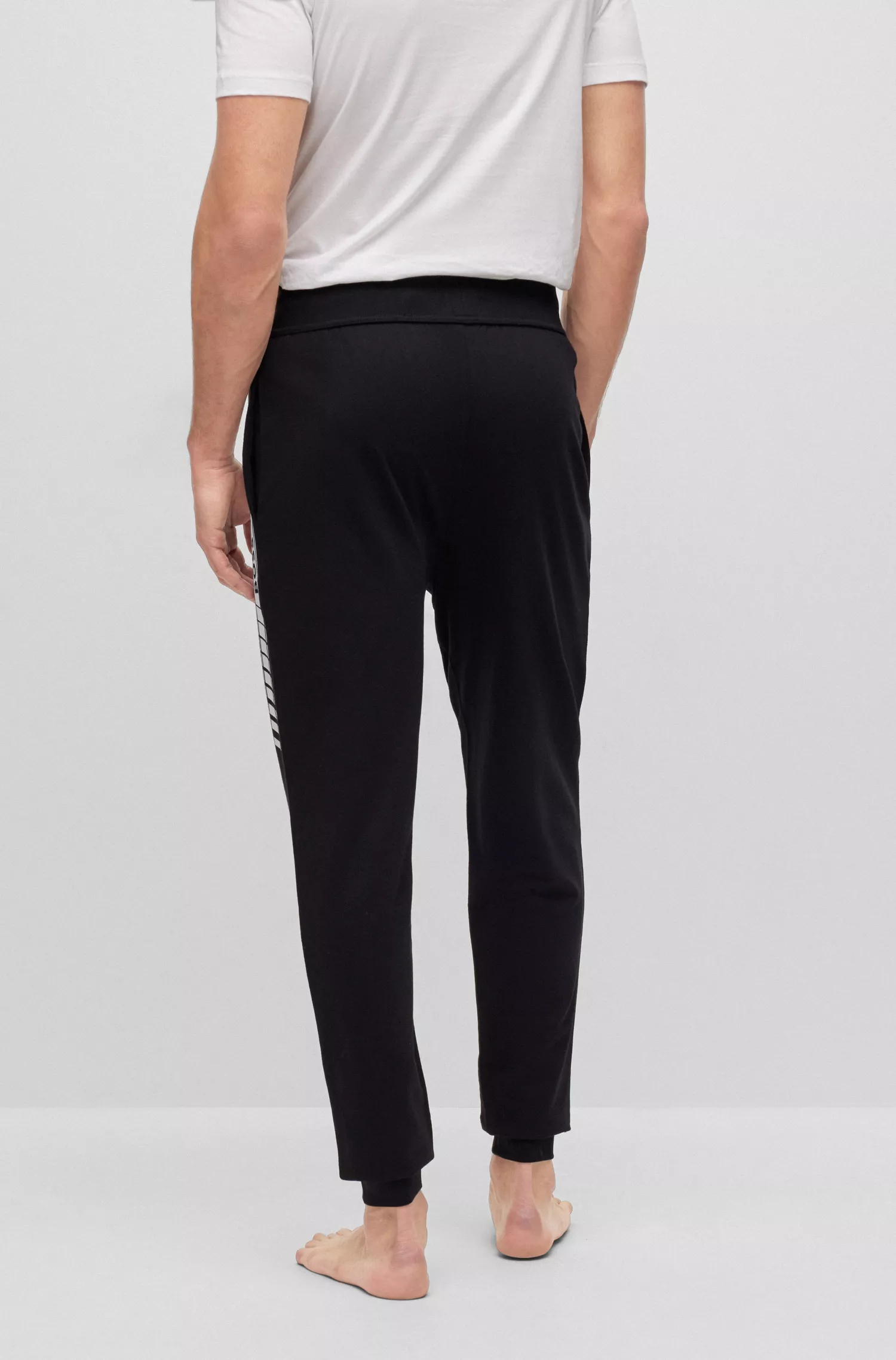 Calça de fato de treino BOSS preta em algodão orgânico com riscas e logótipo.