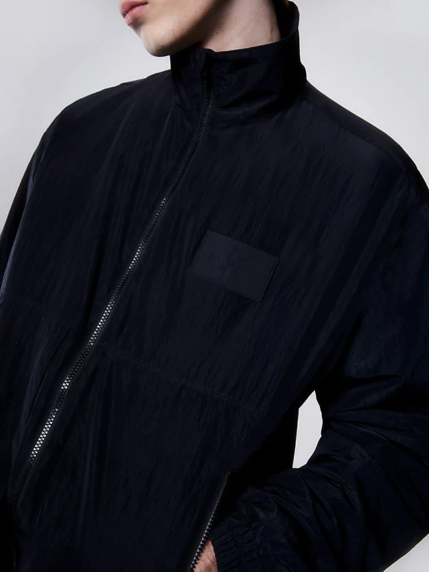 Jaqueta com zíper frontal completo em nylon brilhante.