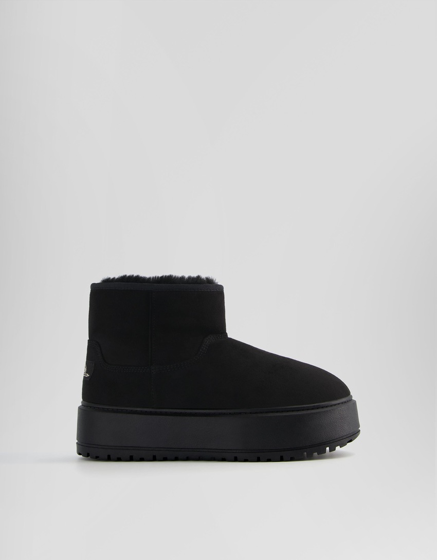 Botas de cano curto com plataforma e forro de pele sintética.