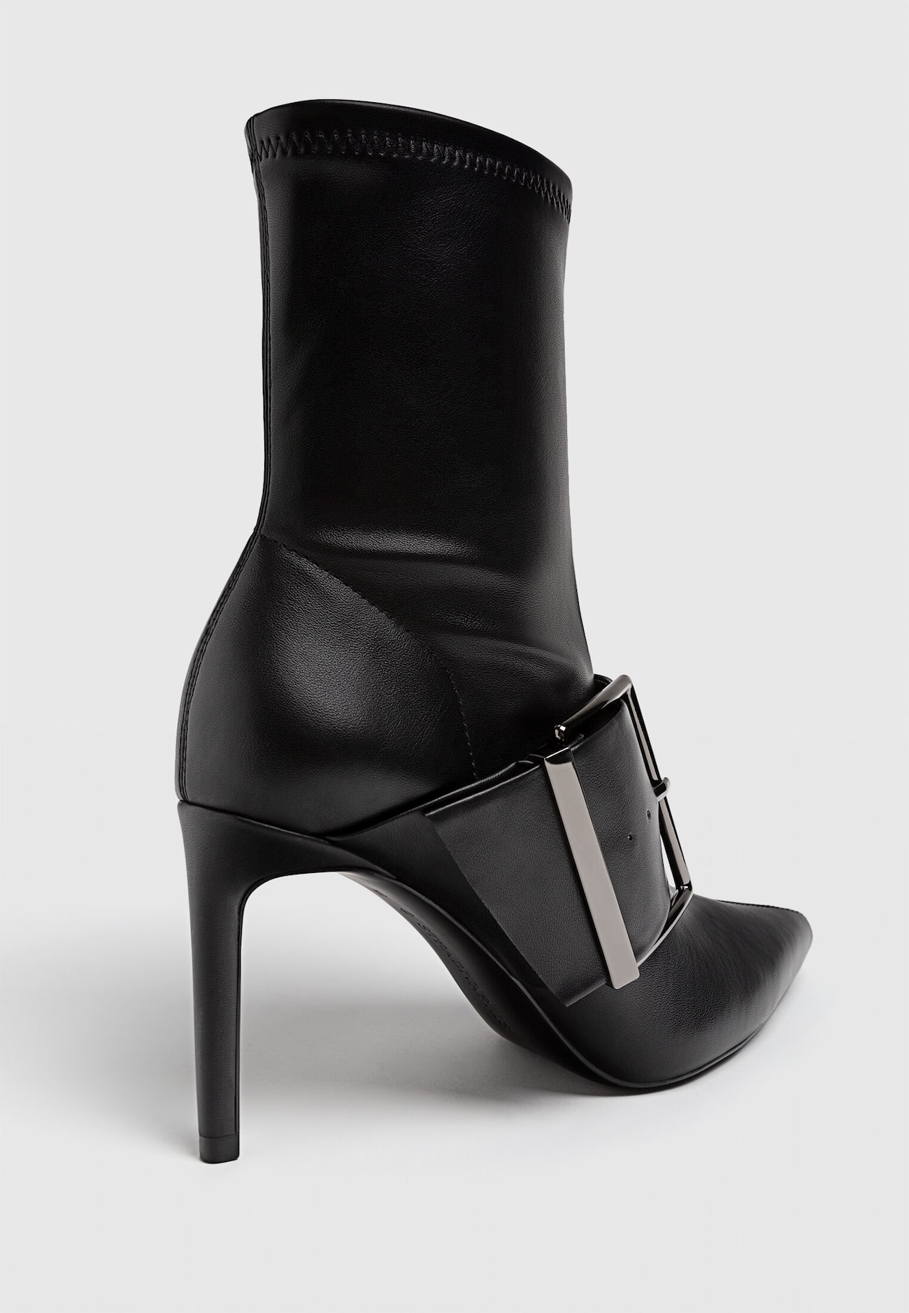 Botas pretas de cano curto com salto alto e fivelas.