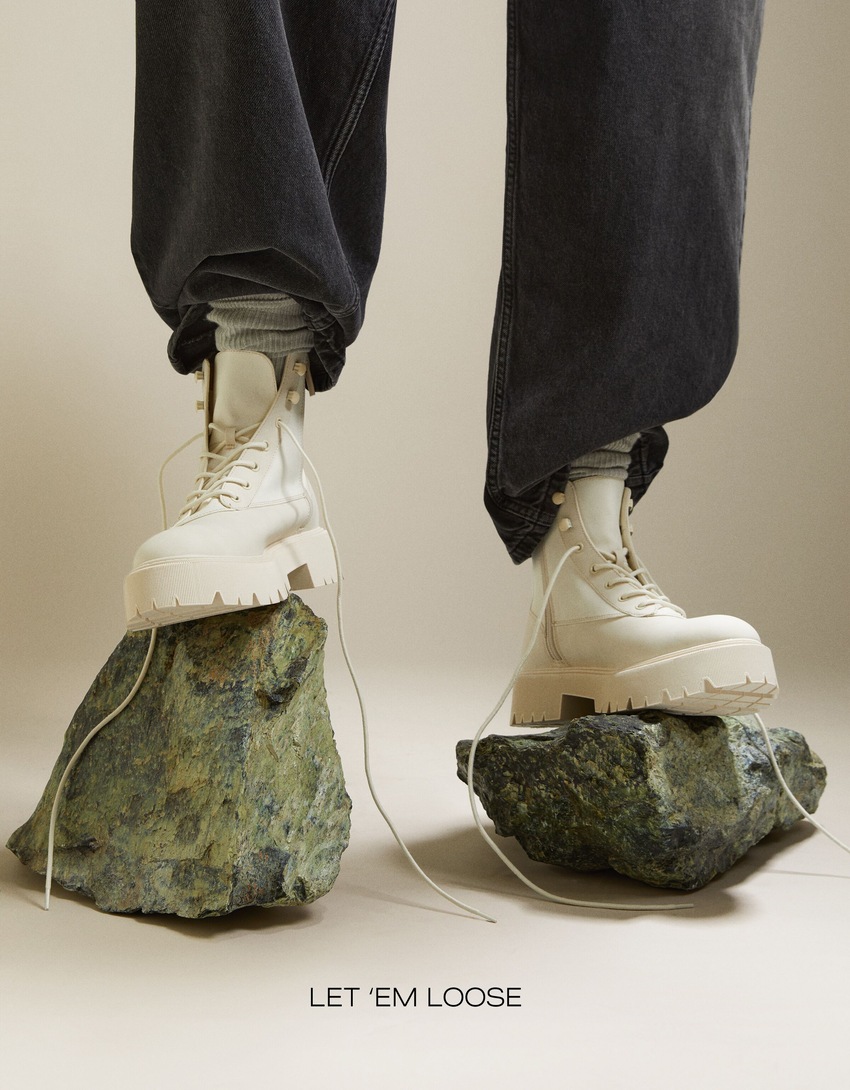 Botas de cano curto com cadarço e modelagem rasteira contrastante