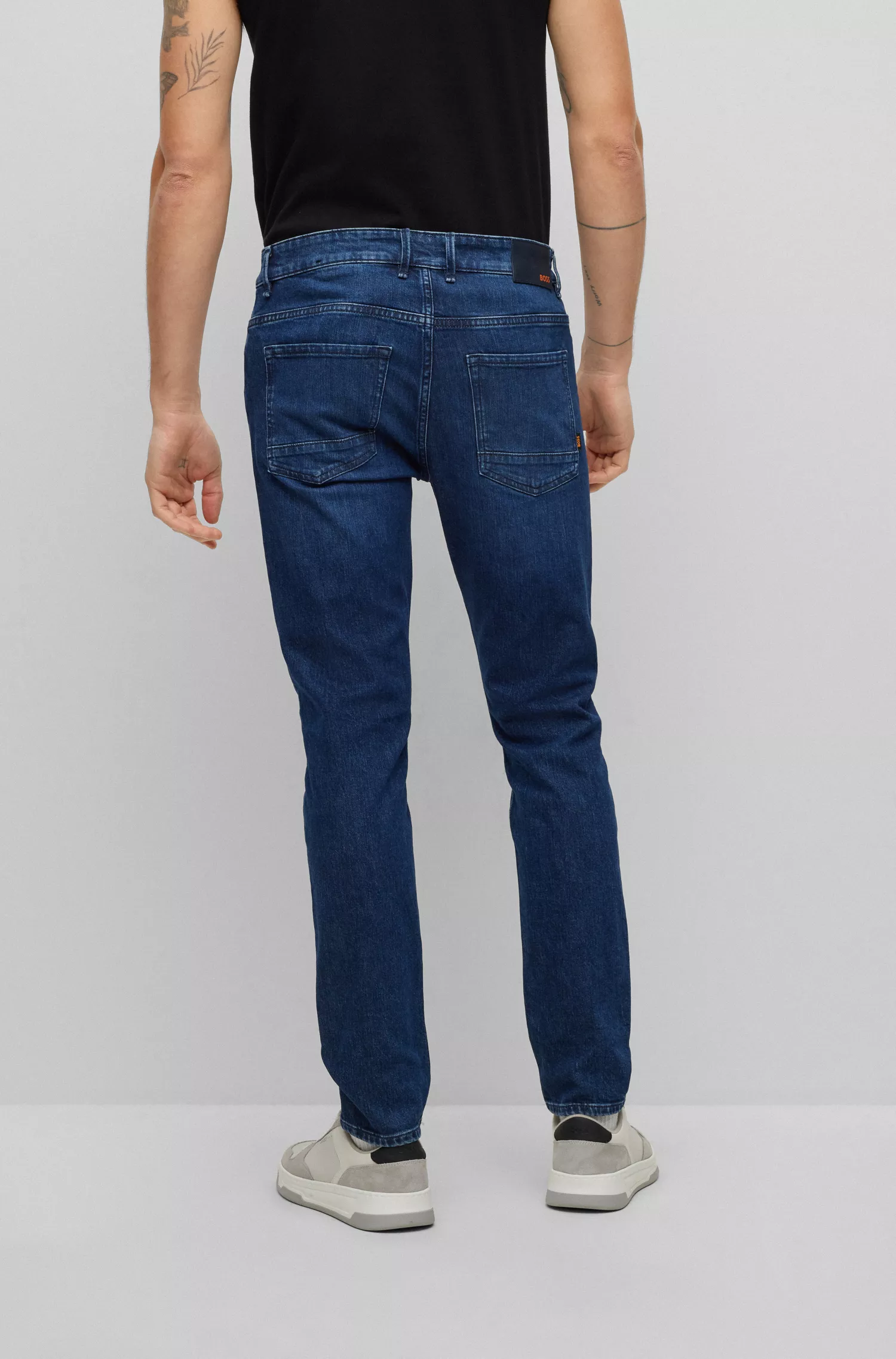 Calça jeans BOSS laranja, corte slim, em denim azul com elasticidade confortável.