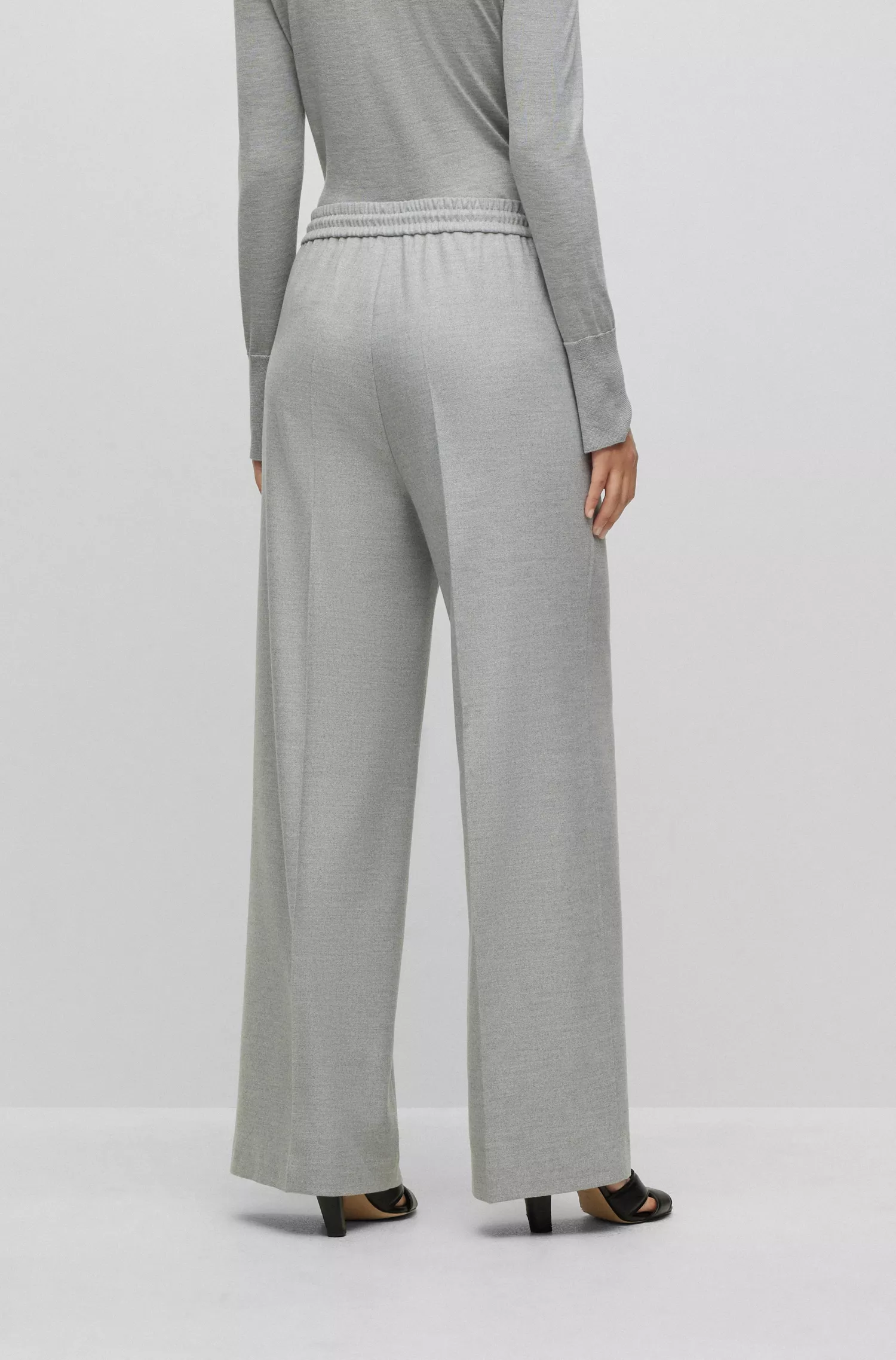 Calça BOSS preta, corte relaxado, com detalhe da marca no cós.
