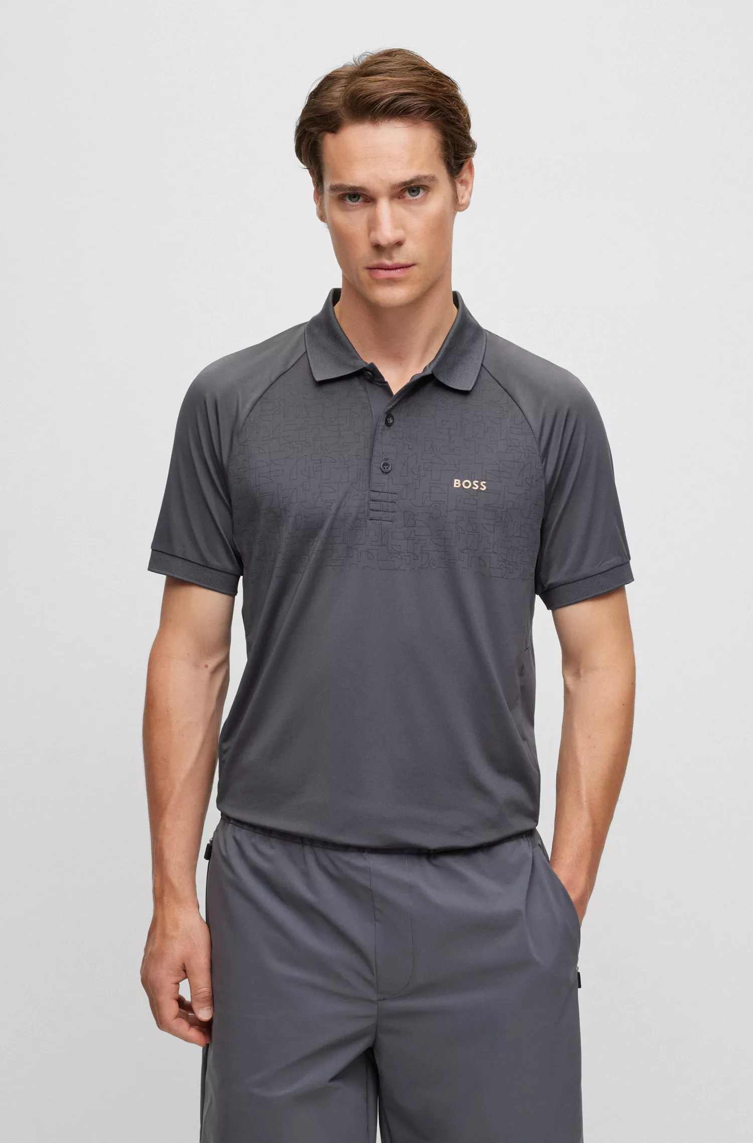 Camisa polo BOSS verde, corte slim, com padrão refletivo decorativo.