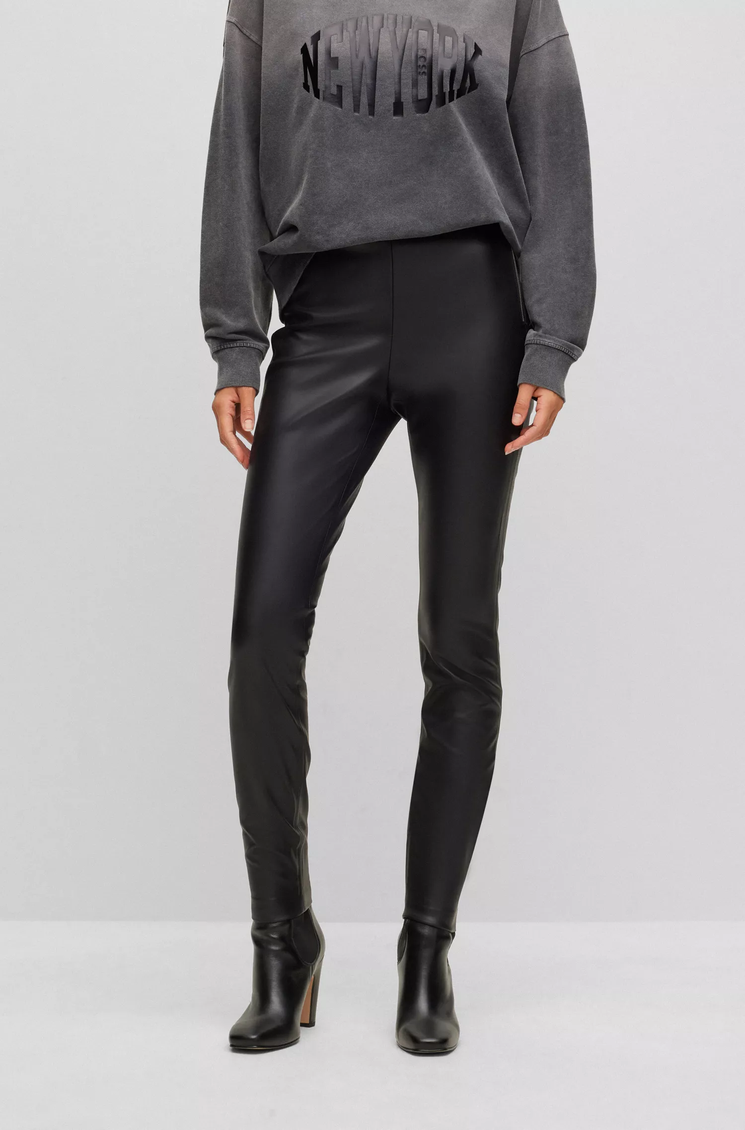 Calça BOSS laranja, corte skinny, cintura alta e zíper lateral.