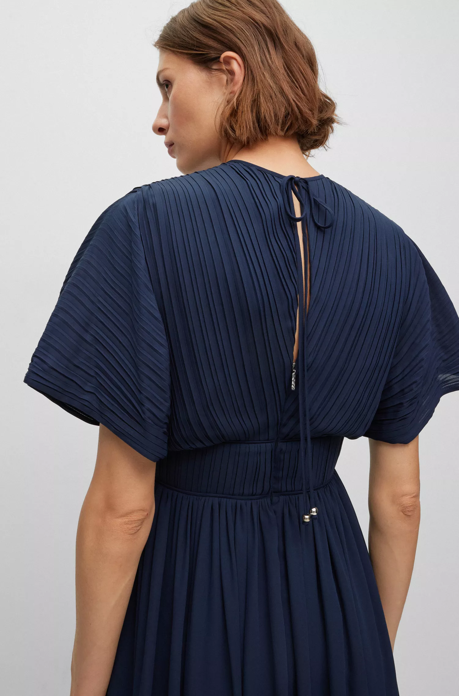 Vestido preto justo da BOSS com amarração nas costas e decote em formato de gota.