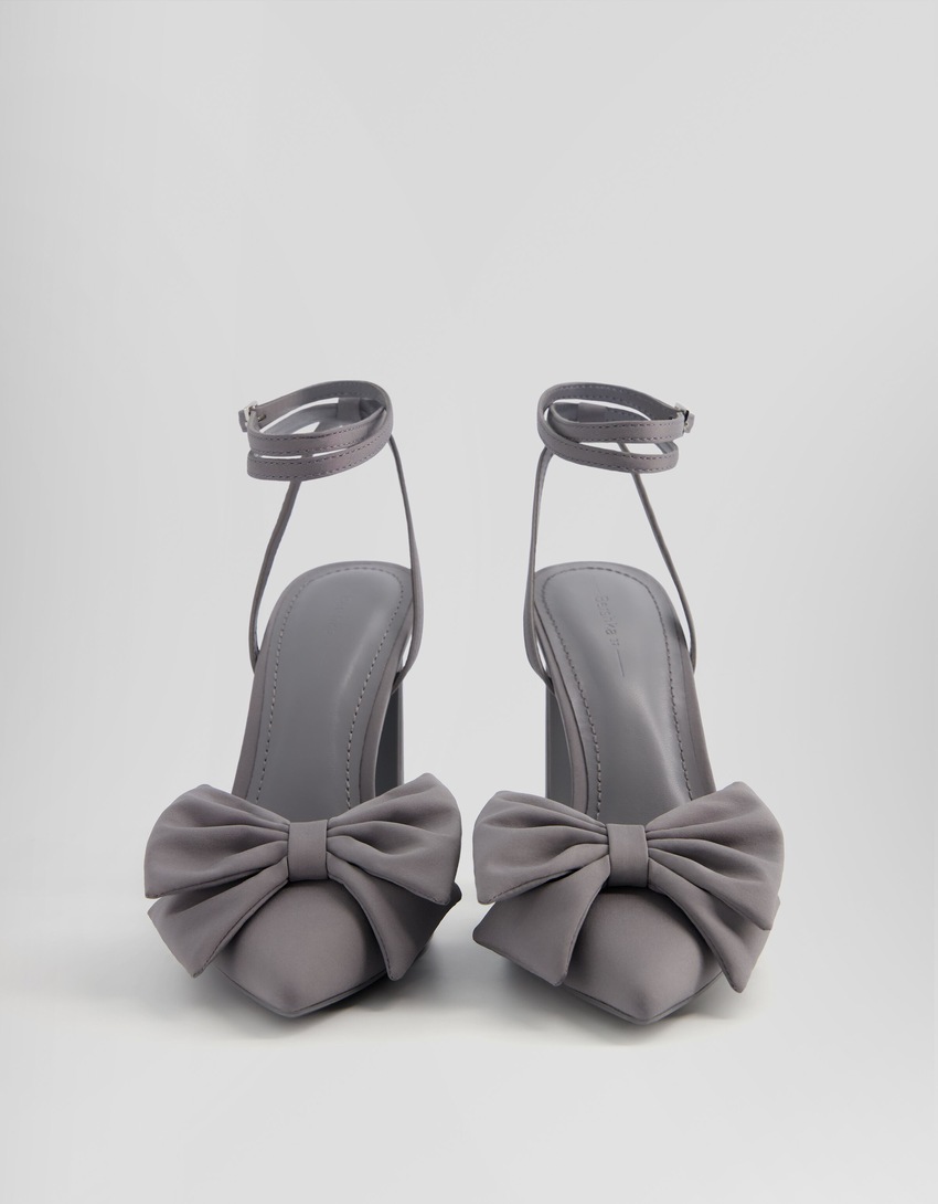 Sapatos de salto alto com tira no tornozelo e laço.