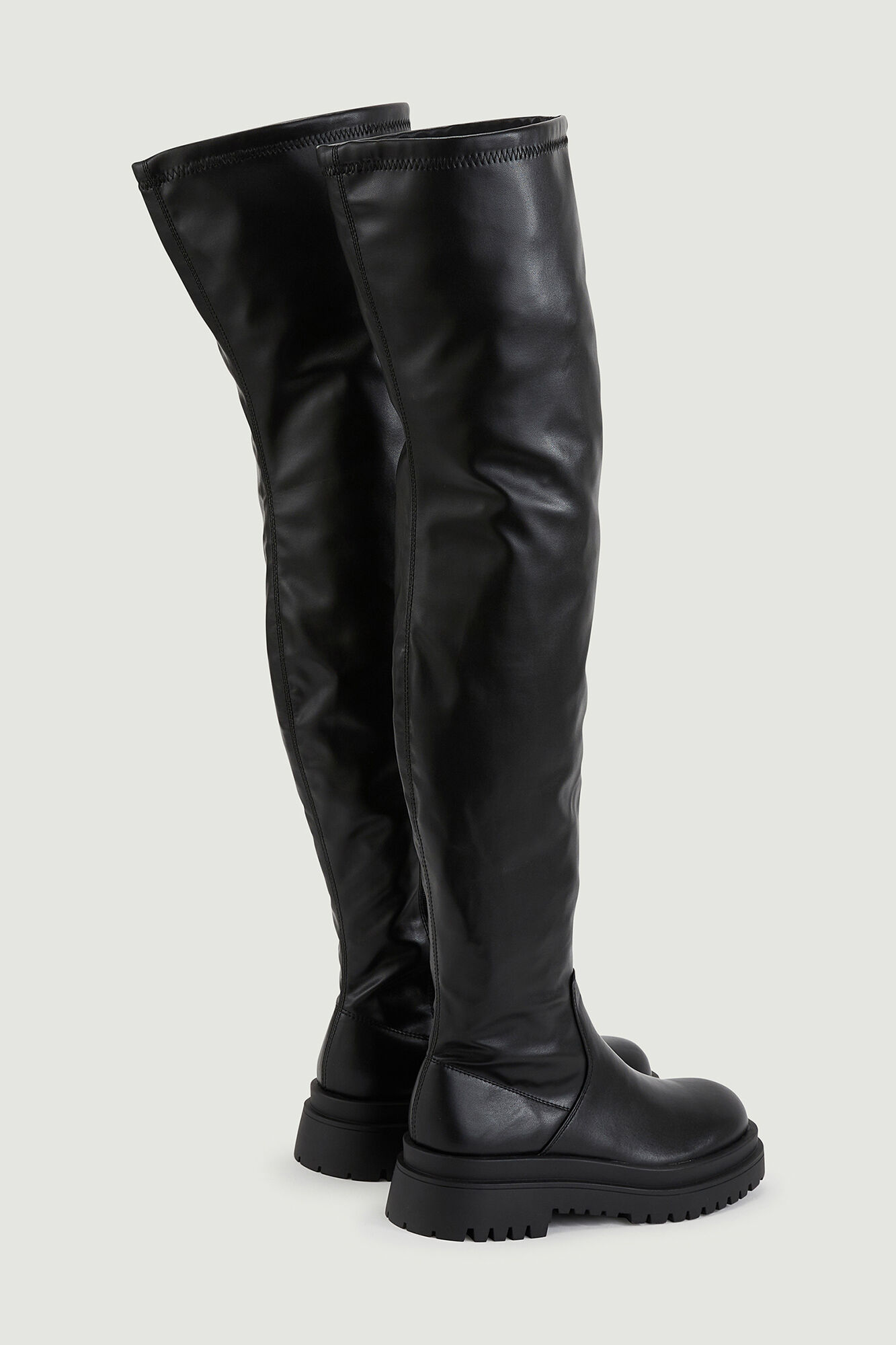 Botas flexíveis de cano alto em couro sintético com sola serrilhada.