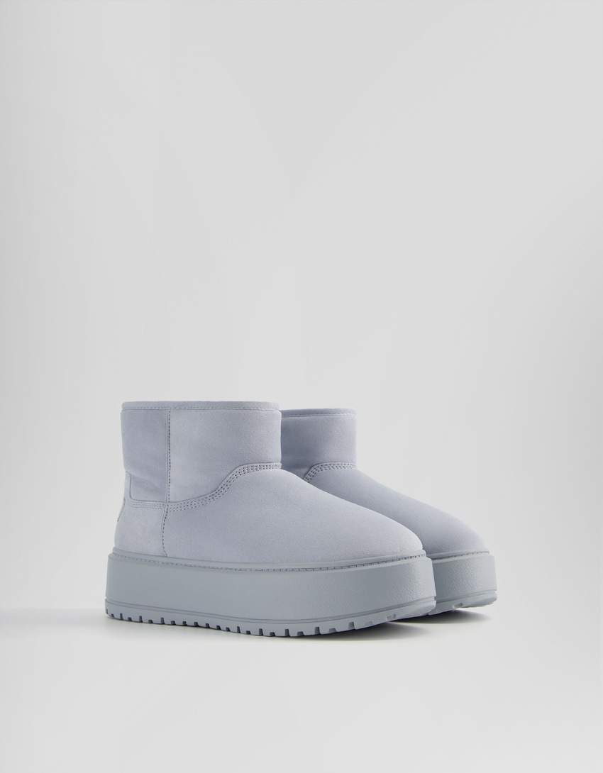 Botas de cano curto com plataforma e forro de pele sintética.